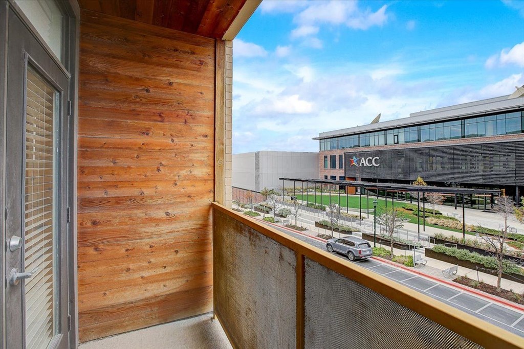 a balcony with a view of a building and a parking lot