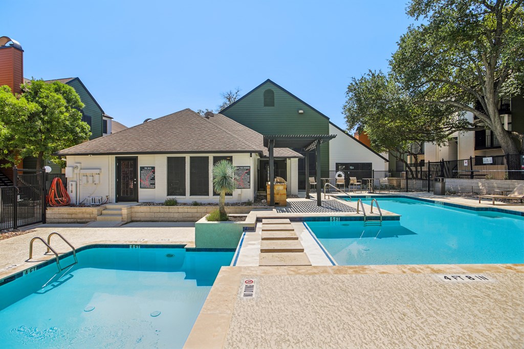 A pool with a slide and a building in the background.