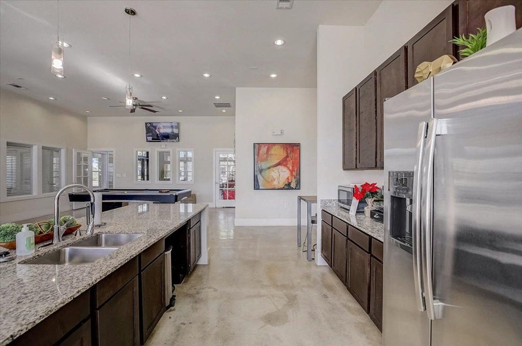 a kitchen with a stainless steel refrigerator and a sink