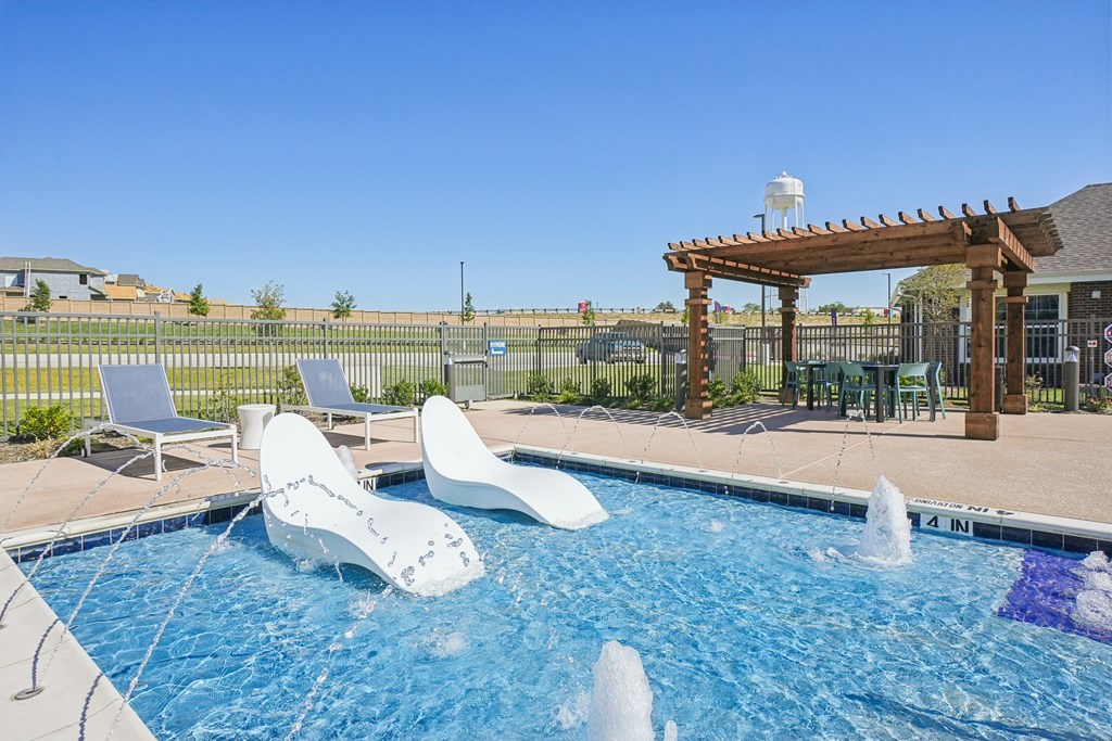 A pool with a waterfall and a pergola.