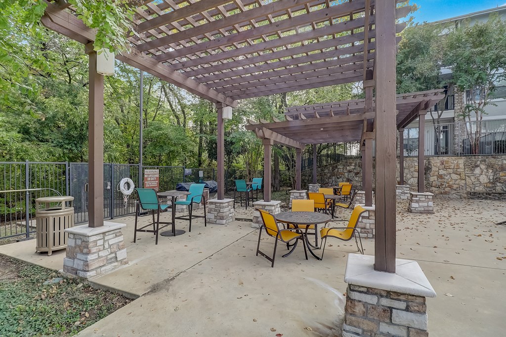 a patio with tables and chairs and a pergola