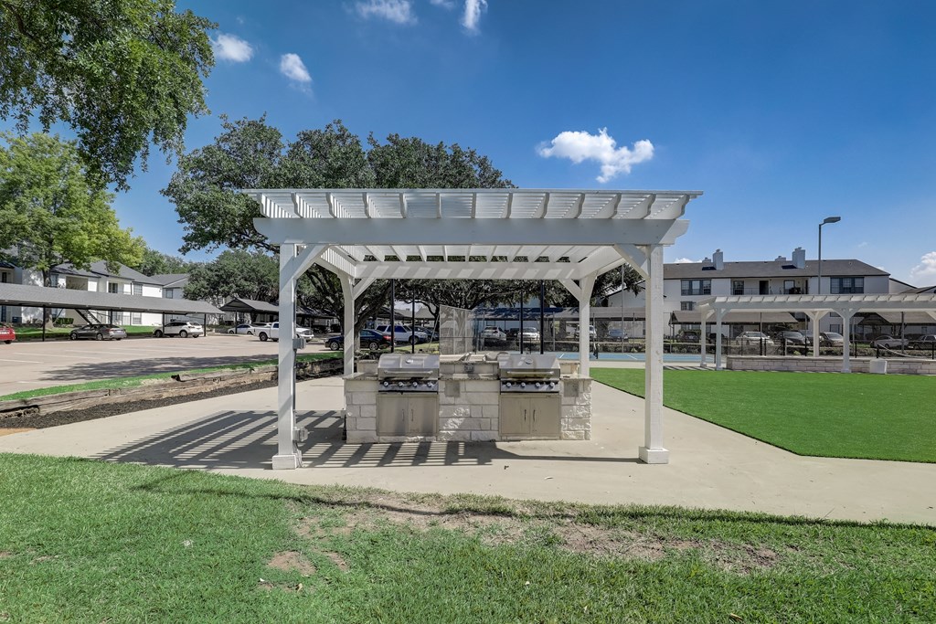 a pavilion in the middle of a park with barbecue pits