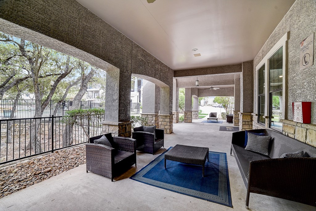 a large patio with furniture and a pool in the background