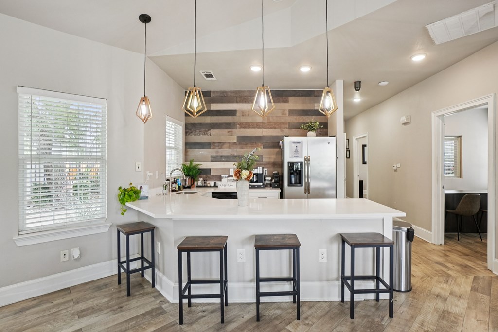 A kitchen with a white island and bar stools.