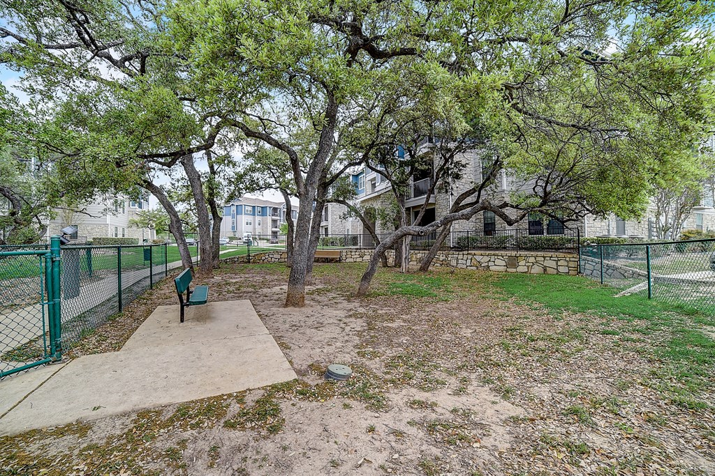 a park with trees and a bench in front of a building