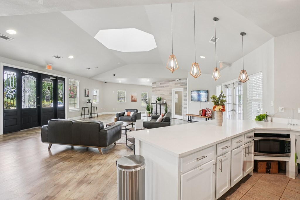 A modern kitchen with a white countertop and a black sofa.