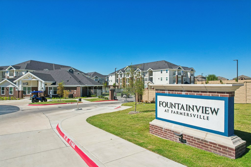 A sign that says Fountainview at Farmersville in front of some houses.