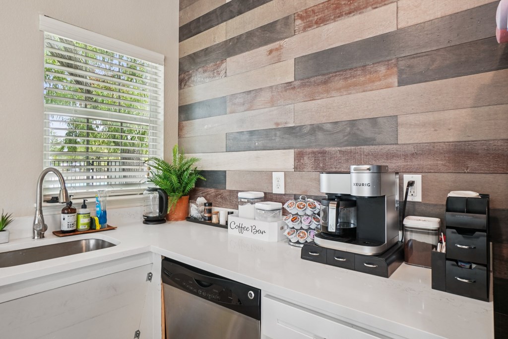 A kitchen with a wooden backsplash and a coffee maker on the counter.