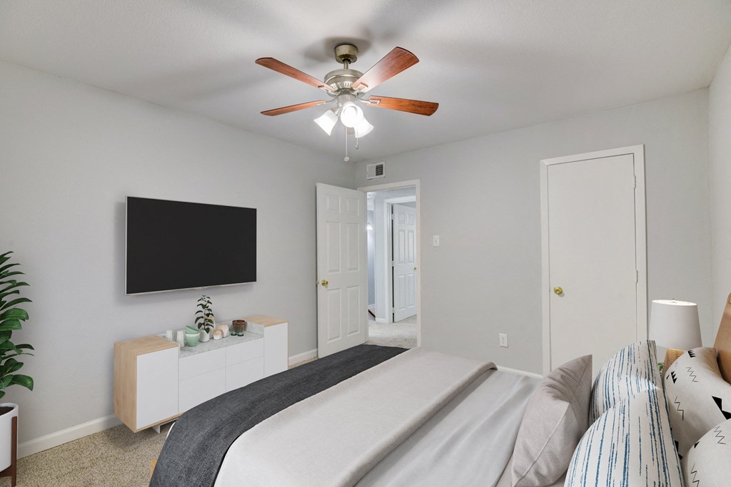 a bedroom with a large bed and a ceiling fan