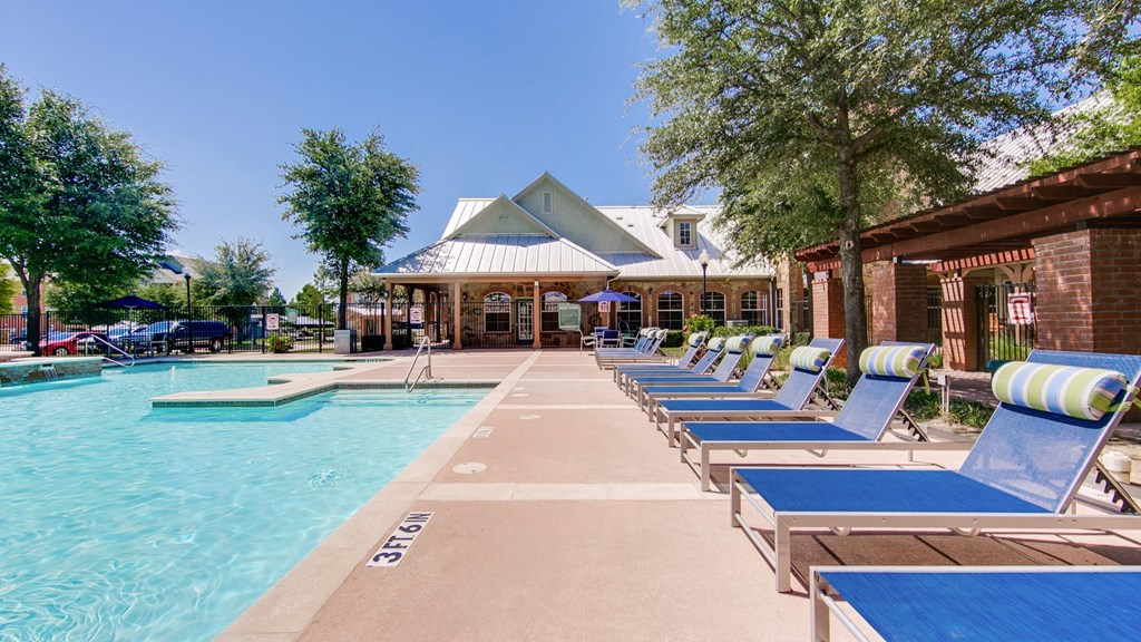 the preserve at ballantyne commons pool with chaise lounge chairs and a building