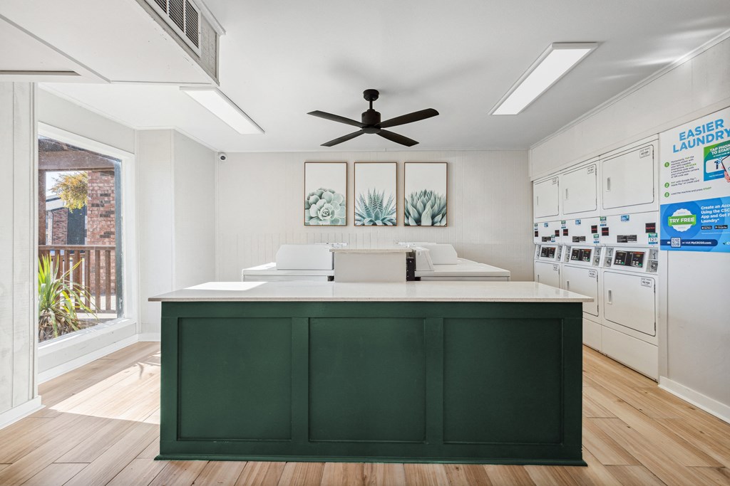 a kitchen with a green island and white cabinets