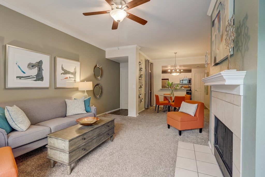 a living room with a fireplace and a ceiling fan