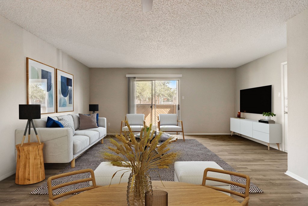 a living room with a couch chairs and a table with a vase of flowers on it