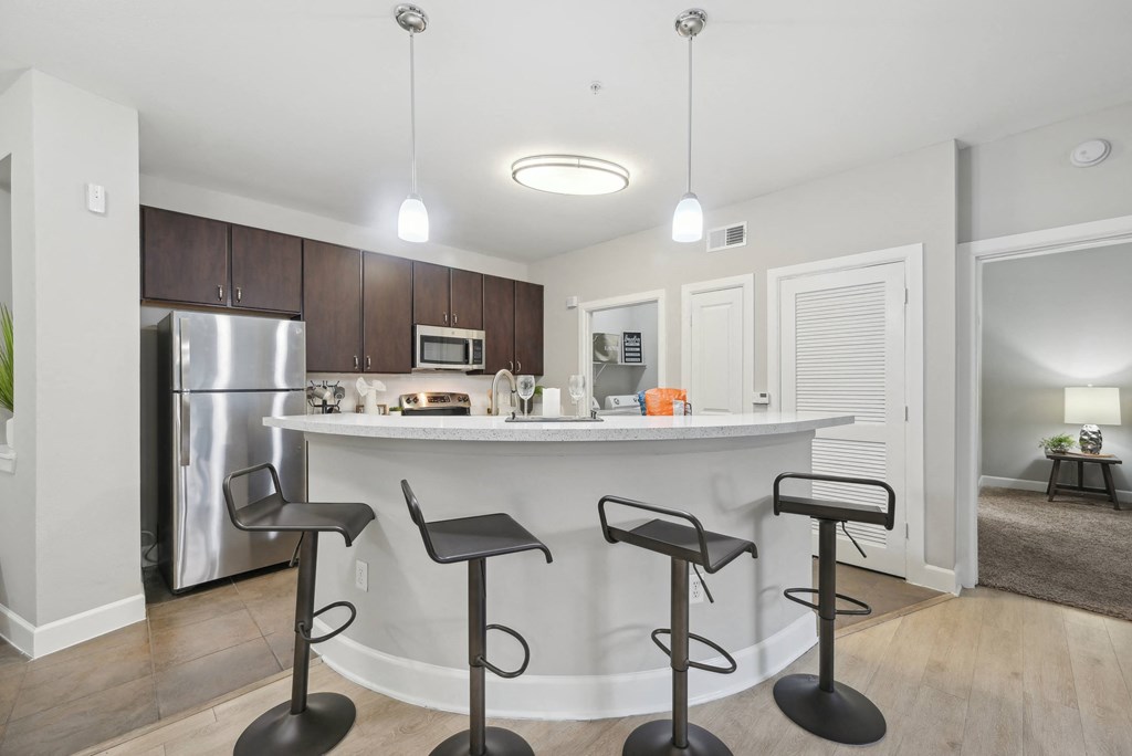 A kitchen with a bar and stools.