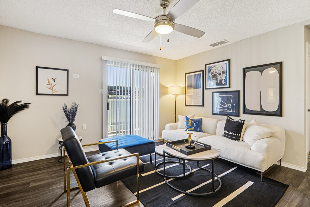 A living room with a black and white color scheme and a ceiling fan.