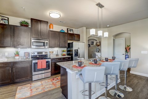 a kitchen with stainless steel appliances and a table with chairs