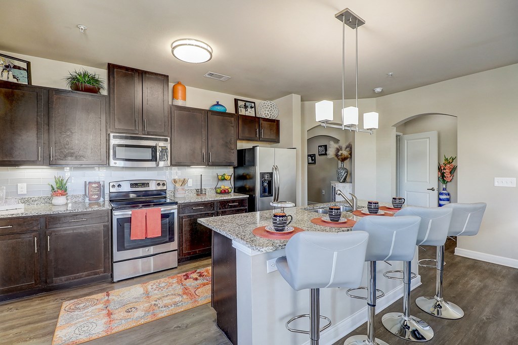 a kitchen with stainless steel appliances and a table with chairs