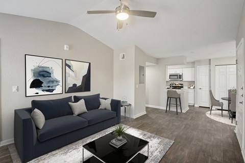 A living room with a dark blue couch and a coffee table in the center.