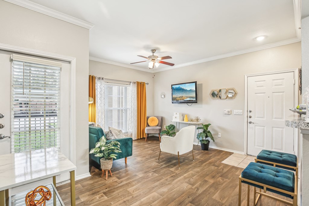 A living room with a green couch and a white chair.