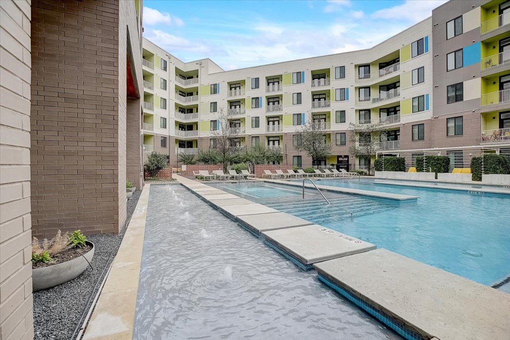 a swimming pool with an apartment building in the background