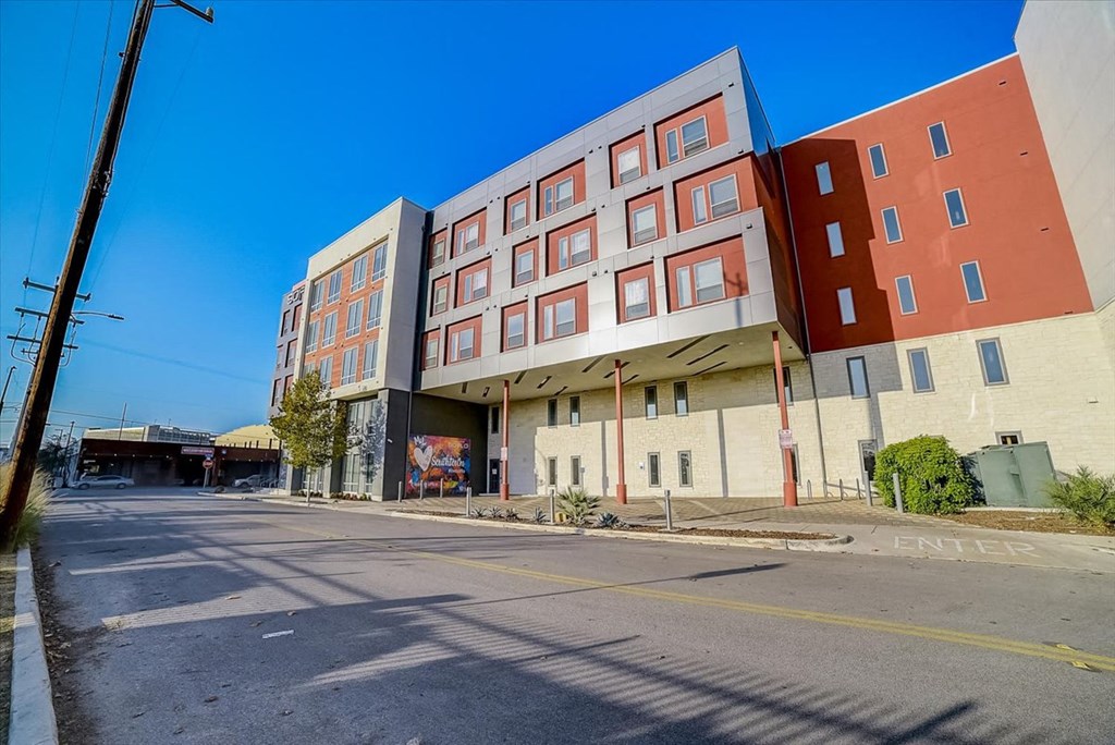 an empty street in front of a large apartment building