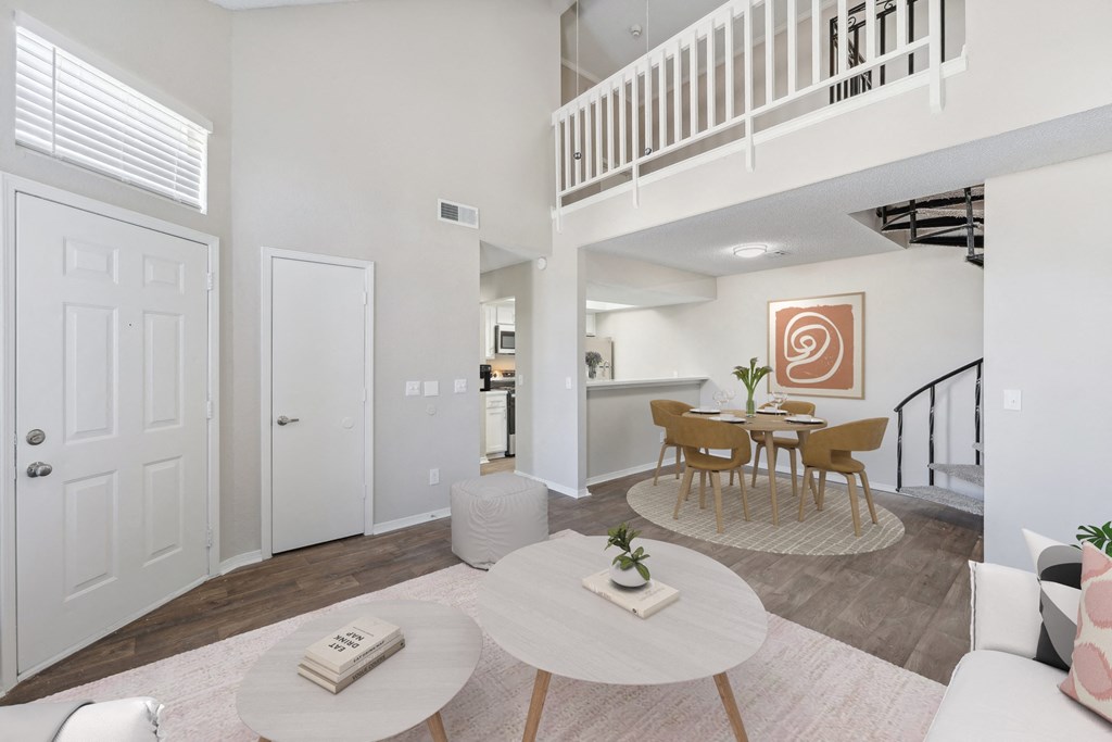 a living room with a dining room and a staircase