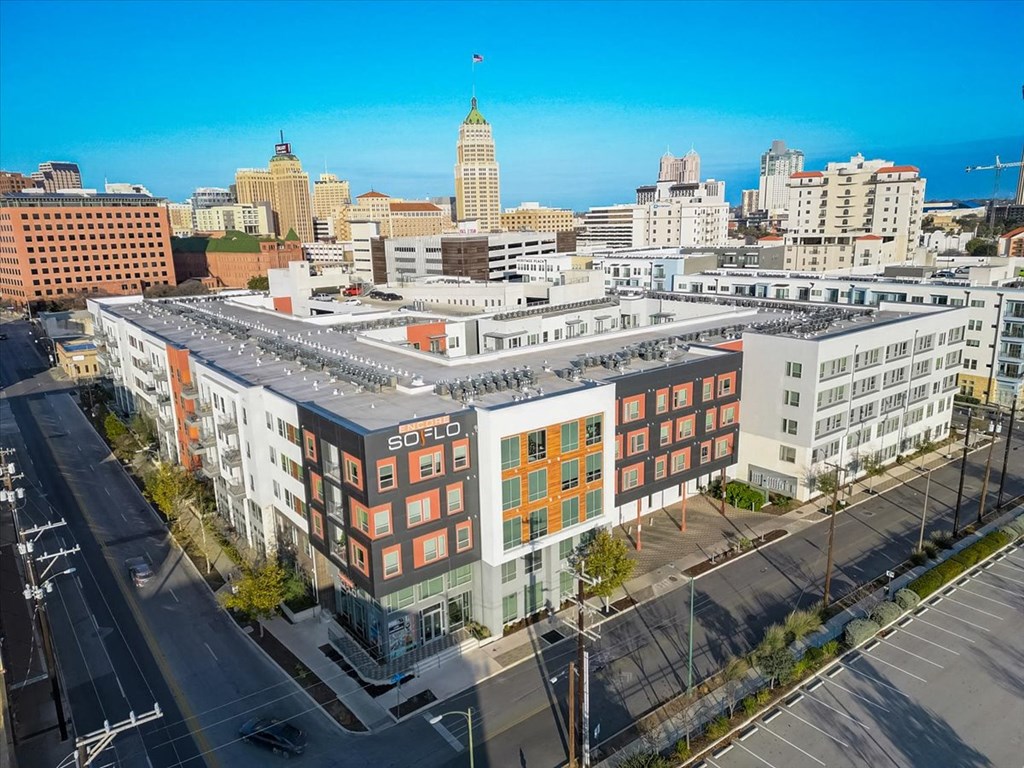an aerial view of a building with a city in the background