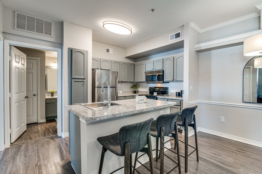 a kitchen with a large island with bar stools