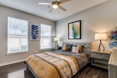 a bedroom with a large bed and a ceiling fan
