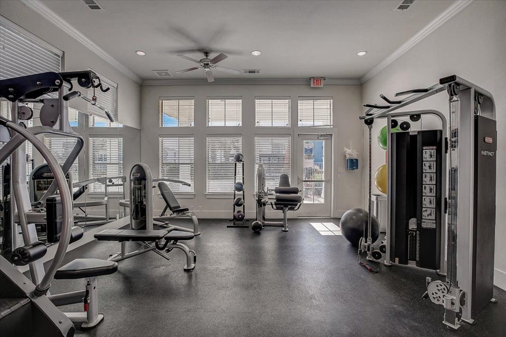 a workout room with exercise equipment and windows