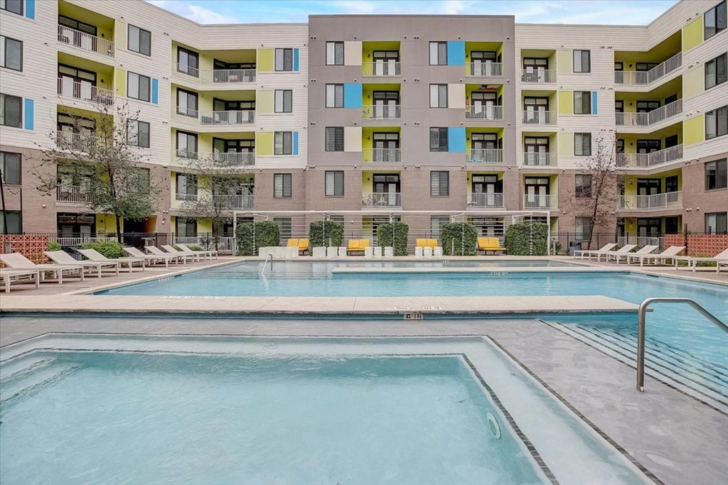 a swimming pool with an apartment building in the background