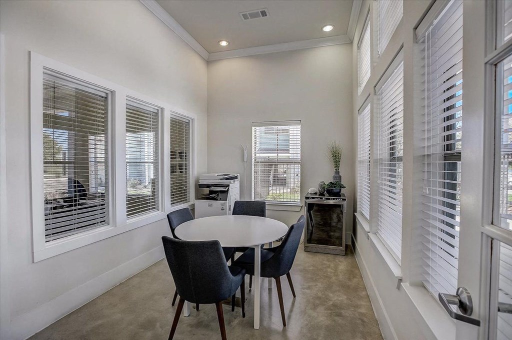 a dining room with a table and chairs next to windows