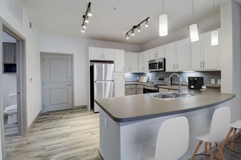 a kitchen with white cabinets and a large counter top
