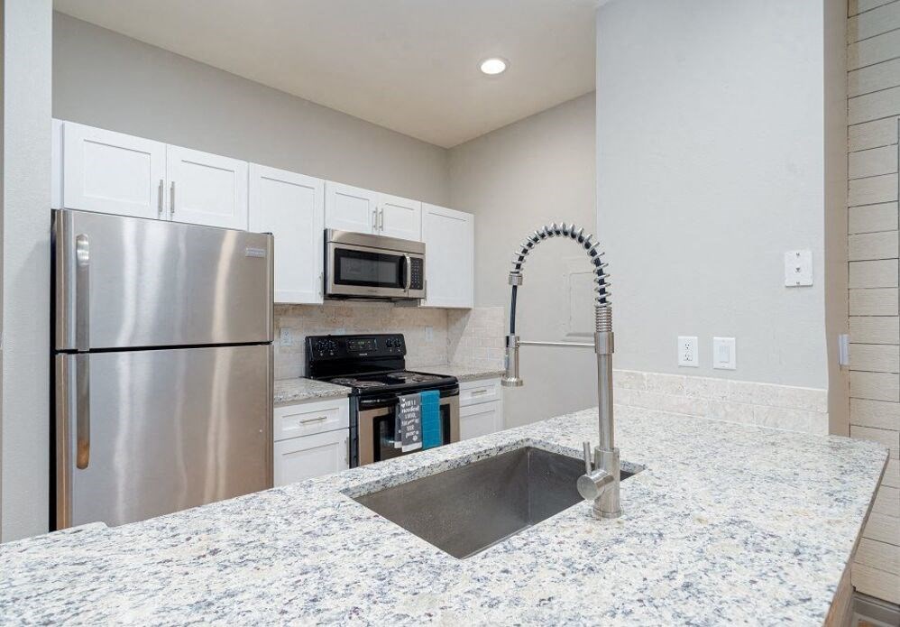 a room with a staircase and a kitchen in it