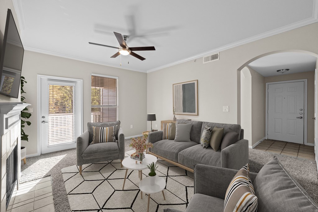 a living room with couches and chairs and a ceiling fan