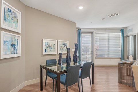 A dining room with a glass table and chairs.