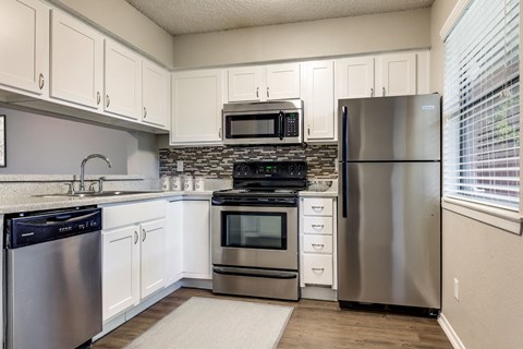 a kitchen with stainless steel appliances and white cabinets