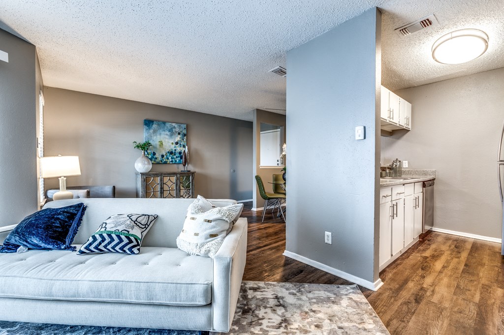 an open living room with a couch and a kitchen