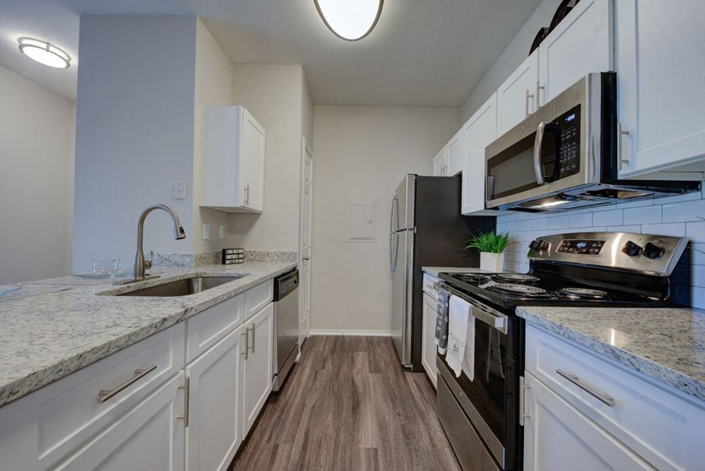 a kitchen with white cabinets and a stove and a sink