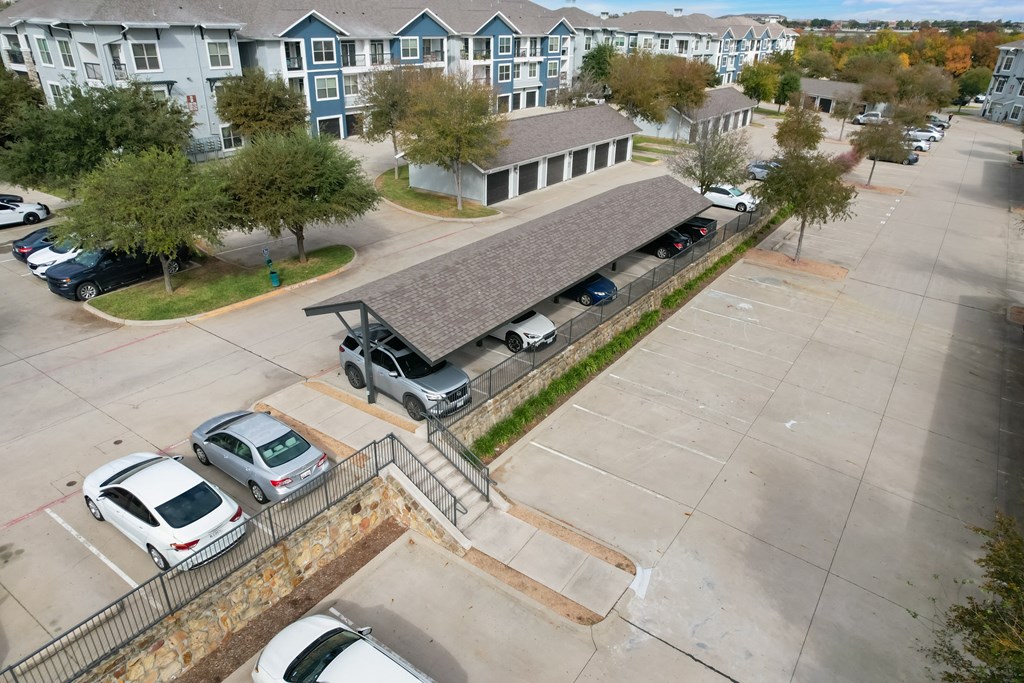 an aerial view of a parking lot and a building with cars parked