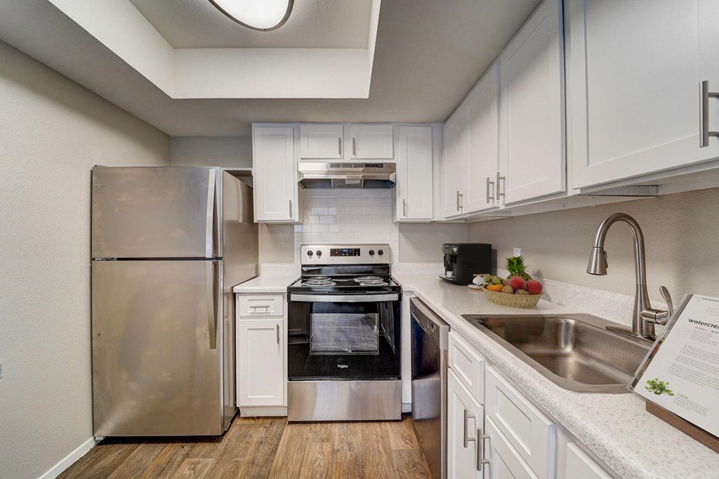 a kitchen with stainless steel appliances and white cabinets