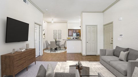 A living room with a grey couch, a coffee table, a flat screen TV, and a wooden cabinet.