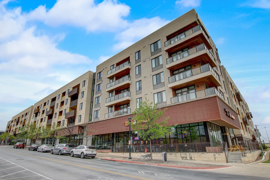a large apartment building on the corner of a city street