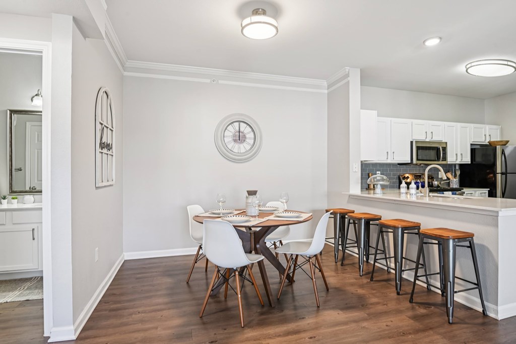 A kitchen with a dining table and chairs.