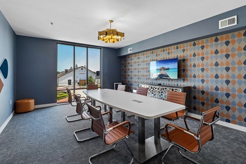 A conference room with a long table and chairs.