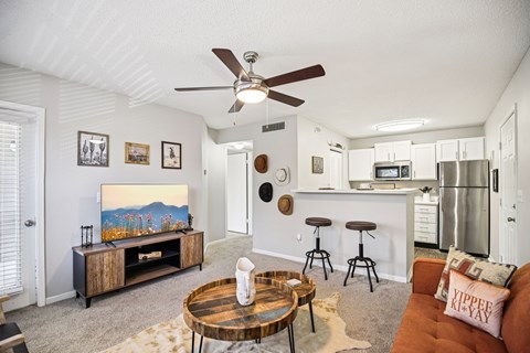 A living room with a brown coffee table and a painting on the wall.