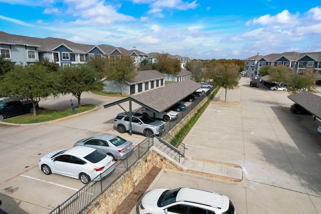 a parking lot with cars parked in front of houses