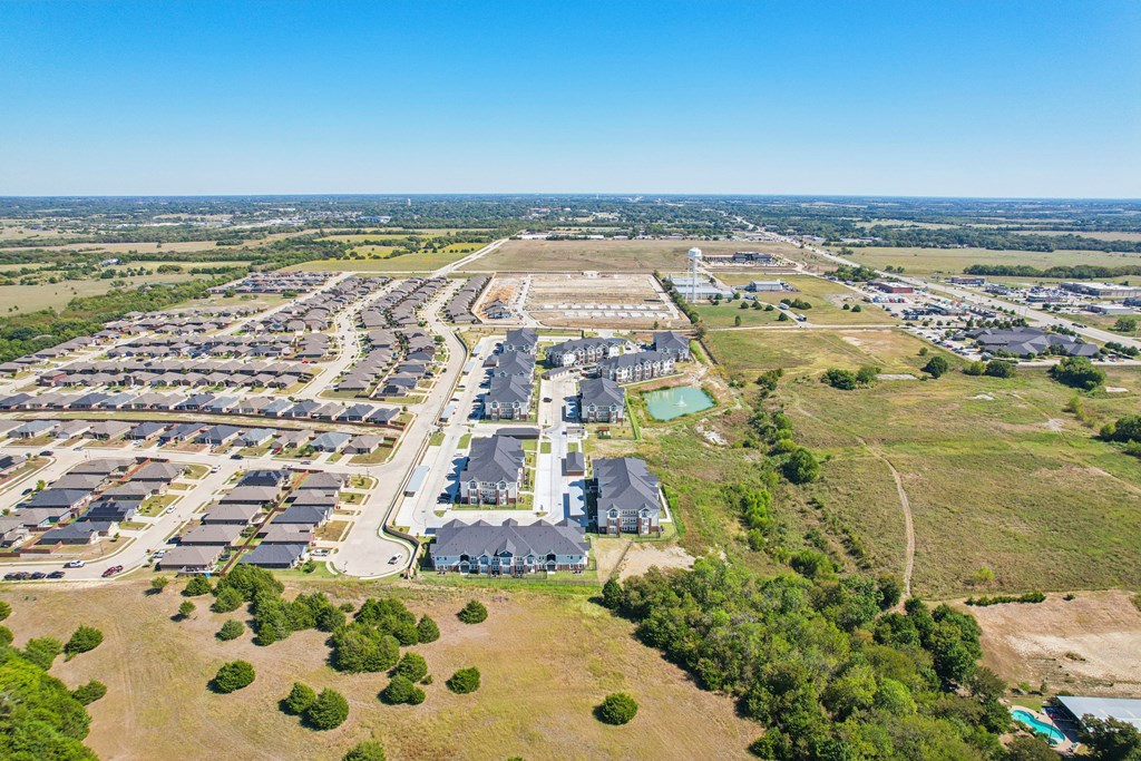A bird's eye view of a residential area with houses and a large building in the center.