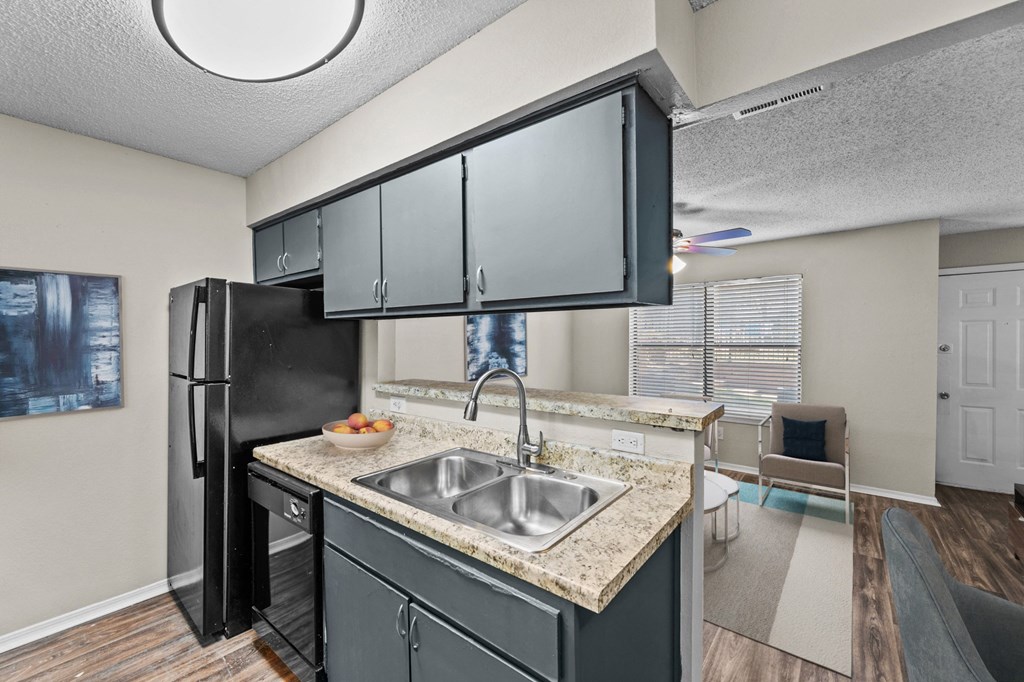 an open kitchen with a sink and a refrigerator