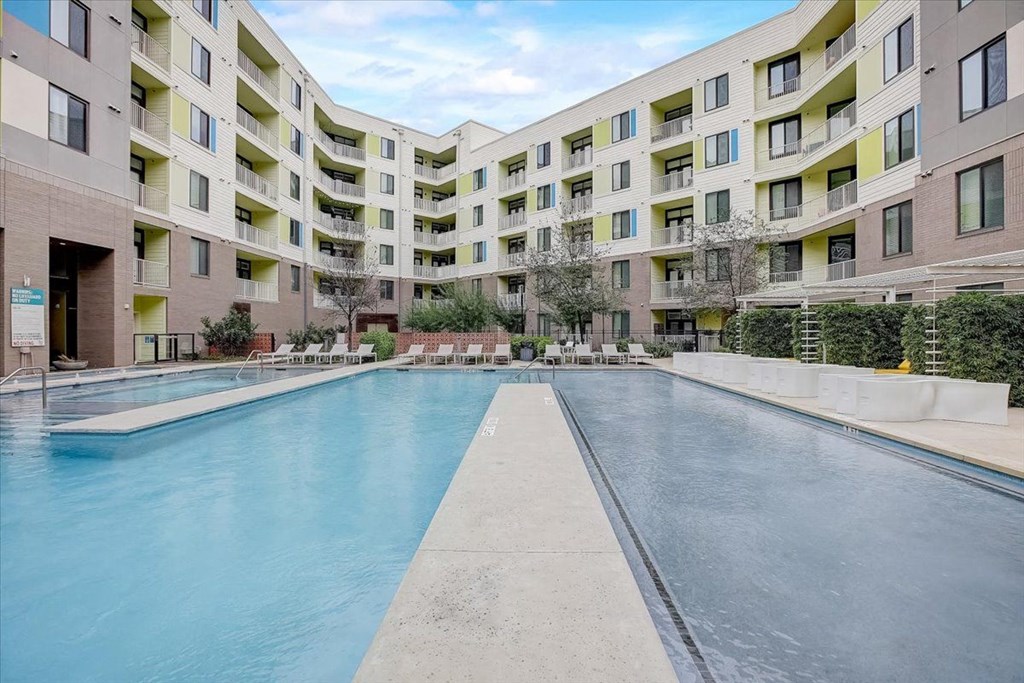 a swimming pool with an apartment building in the background